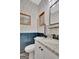 Charming powder room with paneled blue accent wall, decorative wallpaper, and granite counters at 17 Sawtooth Oak Dr, Moreland, GA 30259