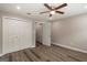 A bedroom features hardwood-style floors, a ceiling fan, a closet, and painted in light neutral shade at 1017 Ridgefield Dr, Peachtree City, GA 30269