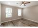 Bright bedroom with a ceiling fan, two windows letting in natural light, and wood-look flooring at 1017 Ridgefield Dr, Peachtree City, GA 30269