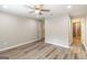 Inviting bedroom with wood-look floors, a ceiling fan, and an adjacent bathroom with a glass shower at 1017 Ridgefield Dr, Peachtree City, GA 30269