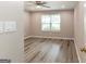 Bright bedroom with wood-look floors, a ceiling fan, and a window providing ample natural light at 1017 Ridgefield Dr, Peachtree City, GA 30269