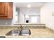 Stainless kitchen sink with granite countertops offering a view into a living space with a fireplace at 1017 Ridgefield Dr, Peachtree City, GA 30269