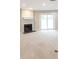 A bright living room featuring a fireplace, carpet, and sliding glass doors at 1017 Ridgefield Dr, Peachtree City, GA 30269