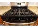 Stainless steel gas stove with granite countertops and black appliances offers a modern kitchen aesthetic at 1017 Ridgefield Dr, Peachtree City, GA 30269