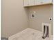 Bright laundry room featuring tile flooring and white cabinetry above connections at 209 Cottonwood Cir, Peachtree City, GA 30269