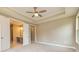 This carpeted main bedroom features a ceiling fan, ensuite bathroom and walk-in closet at 209 Cottonwood Cir, Peachtree City, GA 30269