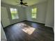 Bright bedroom featuring hardwood floors, two windows offering ample natural light, and neutral paint tones at 7290 Grayson Dr, Riverdale, GA 30296