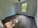 Comfortable bedroom with hardwood floors, natural light from a large window, and neutral paint tones at 7290 Grayson Dr, Riverdale, GA 30296