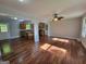 Open-concept living area featuring hardwood floors, a ceiling fan, and easy access to the kitchen and a door to the exterior at 7290 Grayson Dr, Riverdale, GA 30296