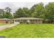 Charming single-story brick home with a well-maintained lawn and inviting curb appeal, shaded by mature trees at 1350 Lori Ct, Conley, GA 30288