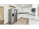 Modern kitchen featuring stainless steel appliances, white cabinets, granite counters, and tile flooring for a sleek design at 1350 Lori Ct, Conley, GA 30288