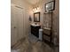 Well-lit bathroom with a black vanity, tile floors, and decorative shelving unit at 1710 Crumbley Rd, Mcdonough, GA 30252