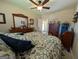 Cozy bedroom featuring a ceiling fan, floral bedding, and natural light from the doorway at 1710 Crumbley Rd, Mcdonough, GA 30252