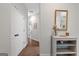 Inviting hallway featuring hardwood floors, crisp white doors, and a stylish console table with gold mirror at 9178 Lakeview Pkwy, Villa Rica, GA 30180