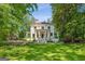 Stately two-story home with classic white columns and a lush green lawn surrounded by mature trees at 818 Springdale Ne Rd, Atlanta, GA 30306