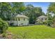 View of home's back exterior, lush yard, and deck, surrounded by greenery and well-maintained grounds at 818 Springdale Ne Rd, Atlanta, GA 30306