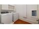 Functional laundry room with washer, dryer, storage, and original hardwood floors at 818 Springdale Ne Rd, Atlanta, GA 30306