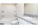 Bright bathroom features a granite countertop, bathtub, white cabinets, and modern fixtures at 455 Prescott Way, Villa Rica, GA 30180