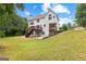 Spacious backyard with a two-story deck, lush greenery, and ample natural light at 44 Willow Leaf Way, Sharpsburg, GA 30277