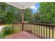 View from a wooden back porch with railings overlooking a lush, green backyard at 44 Willow Leaf Way, Sharpsburg, GA 30277
