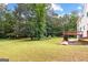 Expansive backyard featuring a wooden deck, lush greenery, and ample space for outdoor activities at 44 Willow Leaf Way, Sharpsburg, GA 30277