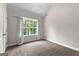 Bright bedroom featuring a large window with patterned curtains and neutral carpet at 44 Willow Leaf Way, Sharpsburg, GA 30277