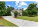 Beautiful home with a long driveway, lush lawn, and a mix of brick and siding exterior at 44 Willow Leaf Way, Sharpsburg, GA 30277