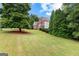 Beautiful home nestled among mature trees and a green lawn, enhancing curb appeal at 44 Willow Leaf Way, Sharpsburg, GA 30277