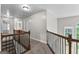 Upstairs hallway with wooden railing, carpet, and natural light, connecting various rooms in the house at 44 Willow Leaf Way, Sharpsburg, GA 30277