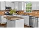 Well-lit kitchen with white cabinets, stainless steel appliances, and granite countertops, ready for cooking and entertaining at 44 Willow Leaf Way, Sharpsburg, GA 30277