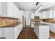 Open kitchen featuring granite countertops, white cabinetry, and a stylish island at 44 Willow Leaf Way, Sharpsburg, GA 30277