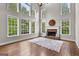 Bright living room featuring a brick fireplace and an array of large windows at 44 Willow Leaf Way, Sharpsburg, GA 30277