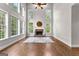 Bright living room with large windows overlooking a landscaped yard and a fireplace at 44 Willow Leaf Way, Sharpsburg, GA 30277