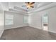 Spacious main bedroom featuring a tray ceiling, ceiling fan, and walk-in closet, creating a peaceful haven at 44 Willow Leaf Way, Sharpsburg, GA 30277