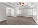 Open main bedroom with a tray ceiling, ceiling fan, and neutral carpet, offering a serene retreat at 44 Willow Leaf Way, Sharpsburg, GA 30277