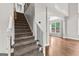 Carpeted staircase with white banister and black iron spindles leads to the upper level, filled with natural light at 44 Willow Leaf Way, Sharpsburg, GA 30277