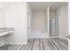 Modern bathroom with gray vinyl flooring, a shower, and a vanity with granite countertop at 451 Prescott Way, Villa Rica, GA 30180