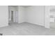 Neutral bedroom with gray carpet, an open doorway to a bath, and view of the kitchen at 451 Prescott Way, Villa Rica, GA 30180