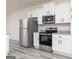 Modern kitchen featuring white cabinets, granite countertops, and stainless steel appliances at 451 Prescott Way, Villa Rica, GA 30180