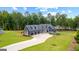 Stunning aerial view of a home with a long driveway, three-car garage, and lush landscaping near a tranquil lake at 180 Lapis Lake Pt, Fayetteville, GA 30215