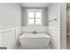 Modern bathroom featuring a freestanding tub, stylish fixtures, and decorative paneling at 180 Lapis Lake Pt, Fayetteville, GA 30215
