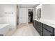 Elegant primary bathroom with double vanity, soaking tub, glass enclosed shower and walk-in closet at 180 Lapis Lake Pt, Fayetteville, GA 30215