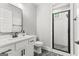 Well-lit bathroom featuring a sleek vanity, toilet, and walk-in shower with black framed glass door at 180 Lapis Lake Pt, Fayetteville, GA 30215