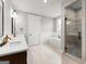 Bright bathroom showcasing a double vanity, soaking tub, and stylish walk-in shower with pebble accents at 180 Lapis Lake Pt, Fayetteville, GA 30215