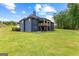 A home with a backyard, covered patio, and a wooded area that extends to a serene lake at 180 Lapis Lake Pt, Fayetteville, GA 30215