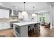 A modern kitchen boasts white cabinets, stainless steel appliances, and a large island with bar seating at 180 Lapis Lake Pt, Fayetteville, GA 30215