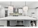 A kitchen features an island with a waterfall countertop, pendant lighting, and stainless steel appliances at 180 Lapis Lake Pt, Fayetteville, GA 30215
