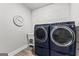Modern laundry room showcasing front-loading washer/dryer set and decorative wall paneling at 180 Lapis Lake Pt, Fayetteville, GA 30215