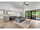 Bright living room with a gray sofa, open floor plan, leading to the kitchen and a view of the outdoor deck at 180 Lapis Lake Pt, Fayetteville, GA 30215