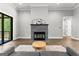 Cozy living room featuring a stone fireplace, hardwood floors, and access to a deck at 180 Lapis Lake Pt, Fayetteville, GA 30215